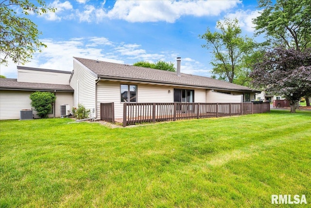 rear view of house featuring central air condition unit, a lawn, and a wooden deck