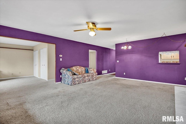 unfurnished room featuring ceiling fan, carpet floors, a chandelier, and baseboards