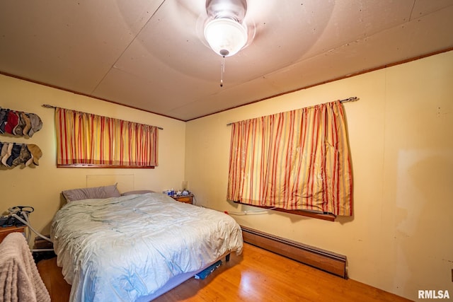 128 W Spruce St, Canton, IL 61520 - bedroom with baseboard heating and wood finished floors