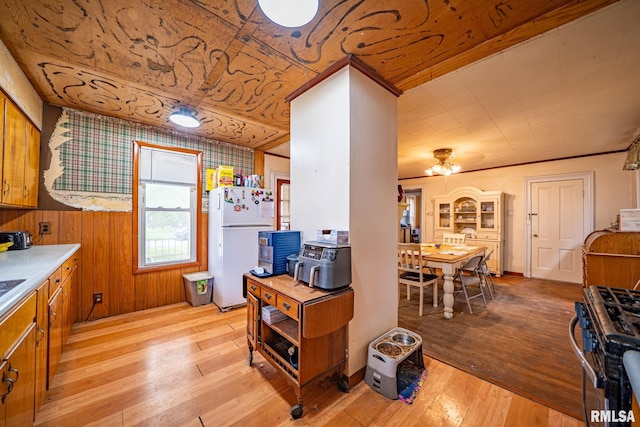 128 W Spruce St, Canton, IL 61520 - kitchen with stainless steel gas range oven, freestanding refrigerator, brown cabinetry, and light wood-style floors