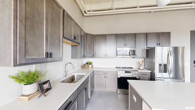1001 SW Adams St Unit 304, Peoria, IL 61602 - kitchen featuring appliances with stainless steel finishes, a sink, decorative backsplash, and light countertops