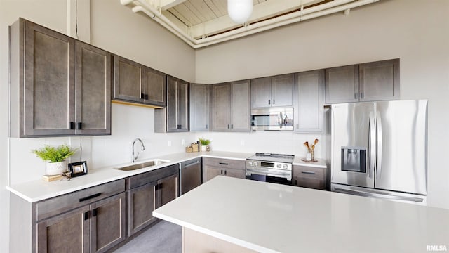 1001 SW Adams St Unit 304, Peoria, IL 61602 - kitchen with appliances with stainless steel finishes, a sink, dark brown cabinetry, light countertops, and tasteful backsplash