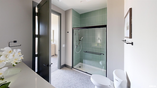 1001 SW Adams St Unit 304, Peoria, IL 61602 - bathroom with a shower stall, toilet, vanity, and tile patterned flooring