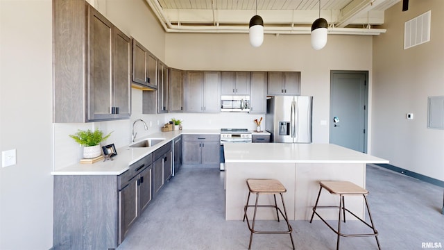1001 SW Adams St Unit 304, Peoria, IL 61602 - kitchen featuring stainless steel appliances, a sink, a towering ceiling, a kitchen bar, and a kitchen island
