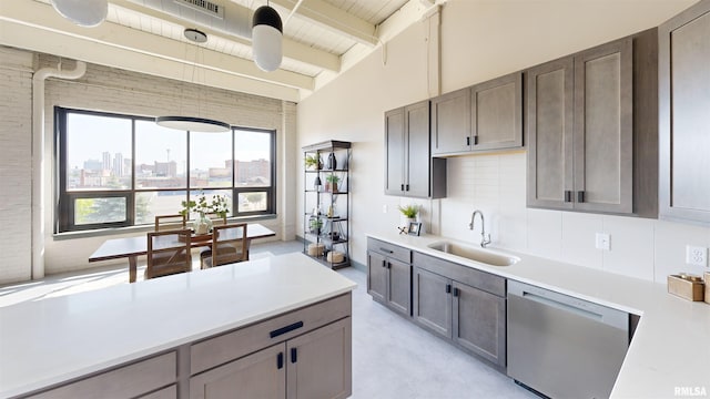 1001 SW Adams St Unit 304, Peoria, IL 61602 - kitchen with a sink, stainless steel dishwasher, light countertops, beamed ceiling, and backsplash