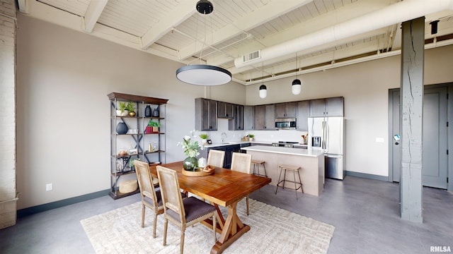 1001 SW Adams St Unit 304, Peoria, IL 61602 - dining space with finished concrete floors, a towering ceiling, baseboards, and wood ceiling with exposed beams