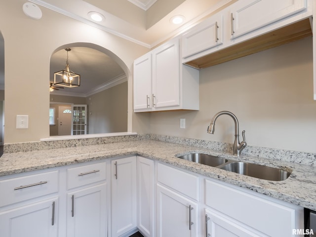 2205 N N St, Peoria, IL 61604 - kitchen featuring a sink, crown molding, white cabinetry, arched walkways, and pendant lighting