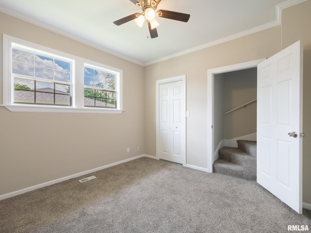 2205 N N St, Peoria, IL 61604 - unfurnished bedroom featuring carpet flooring, ornamental molding, baseboards, a ceiling fan, and a closet