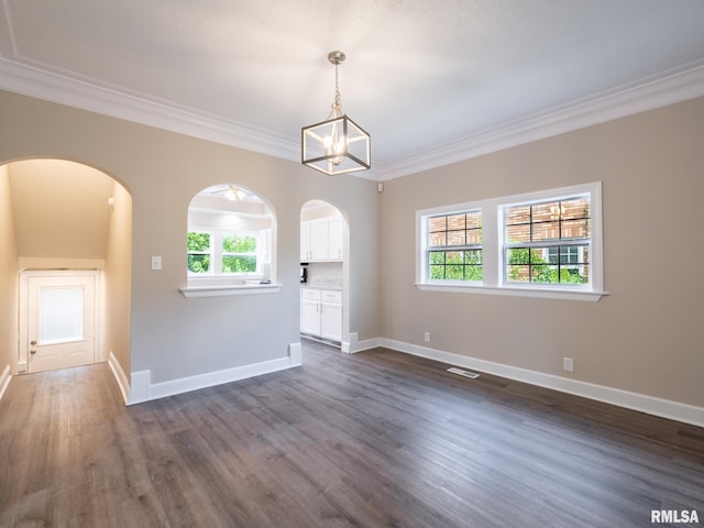 2205 N N St, Peoria, IL 61604 - spare room featuring arched walkways, crown molding, healthy amount of natural light, dark wood finished floors, and baseboards