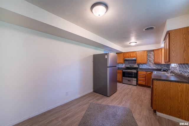 2706 W Millbrook Ct, Peoria, IL 61615 - kitchen featuring stainless steel appliances, a sink, dark countertops, under cabinet range hood, and brown cabinets