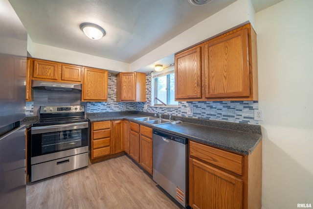 2706 W Millbrook Ct, Peoria, IL 61615 - kitchen featuring stainless steel appliances, under cabinet range hood, a sink, light wood-style flooring, and dark countertops