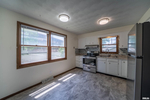 2706 W Millbrook Ct, Peoria, IL 61615 - kitchen featuring appliances with stainless steel finishes, under cabinet range hood, a sink, white cabinets, and tasteful backsplash
