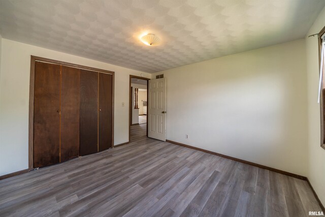 2706 W Millbrook Ct, Peoria, IL 61615 - unfurnished bedroom featuring baseboards, wood finished floors, and a closet