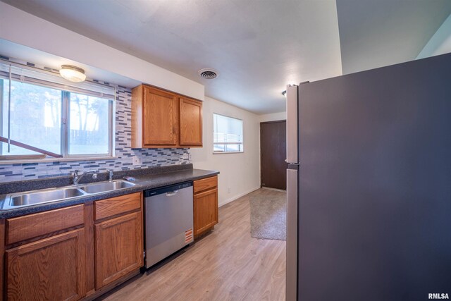 2706 W Millbrook Ct, Peoria, IL 61615 - kitchen featuring stainless steel appliances, a sink, light wood finished floors, dark countertops, and brown cabinetry