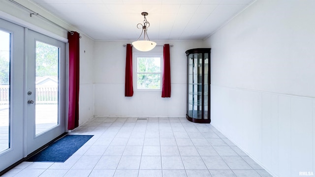 7409 N Piccadilly Pl, Peoria, IL 61614 - unfurnished dining area featuring crown molding, a wainscoted wall, french doors, and light tile patterned floors