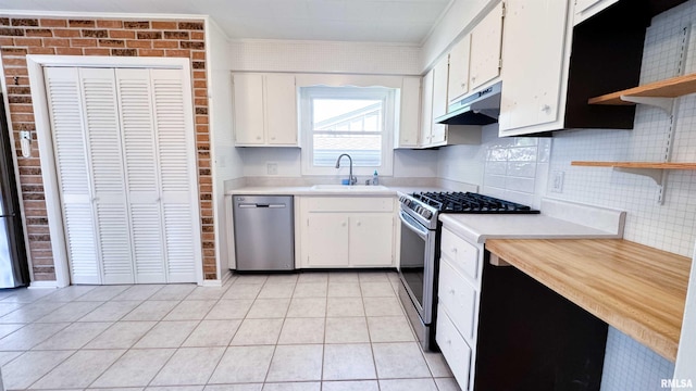 7409 N Piccadilly Pl, Peoria, IL 61614 - kitchen with appliances with stainless steel finishes, under cabinet range hood, open shelves, light countertops, and brick wall