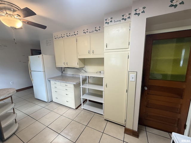 130 E Maple St, Roseville, IL 61473 - kitchen with freestanding refrigerator, light countertops, light tile patterned flooring, ceiling fan, and baseboards