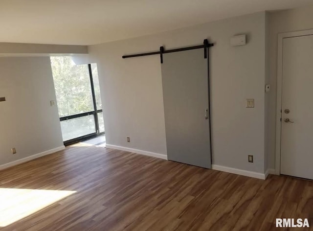 125 SW Jefferson Ave Unit W4S, Peoria, IL 61602 - unfurnished room featuring wood finished floors, a barn door, and baseboards