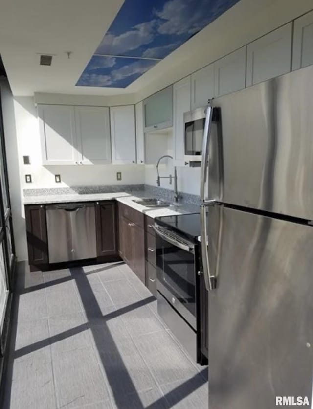 125 SW Jefferson Ave Unit W4S, Peoria, IL 61602 - kitchen with appliances with stainless steel finishes, a sink, light countertops, and tile patterned floors