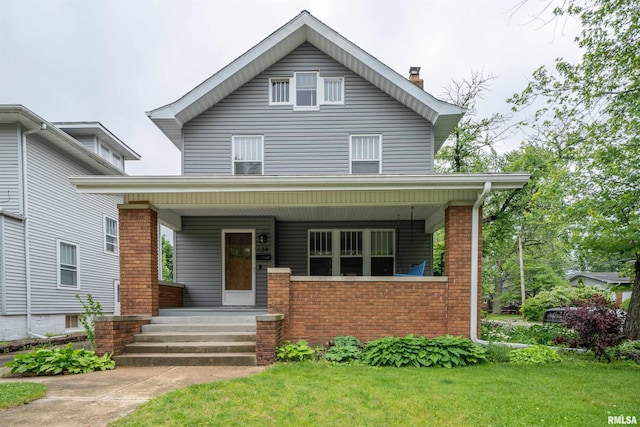 134 W Hanssler Pl, Peoria, IL 61604 - american foursquare style home with covered porch, brick siding, a chimney, and a front yard