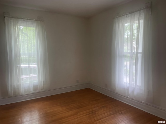 623 S Randolph St, Macomb, IL 61455 - empty room with healthy amount of natural light, wood finished floors, and baseboards