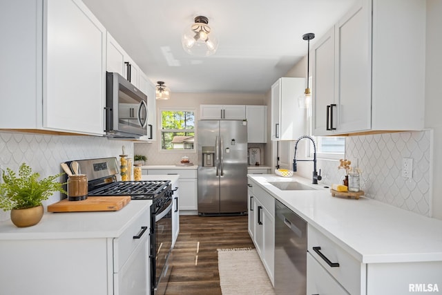 3348 W Lisa Ln, Peoria, IL 61615 - kitchen featuring stainless steel appliances, a sink, dark wood-type flooring, tasteful backsplash, and light countertops