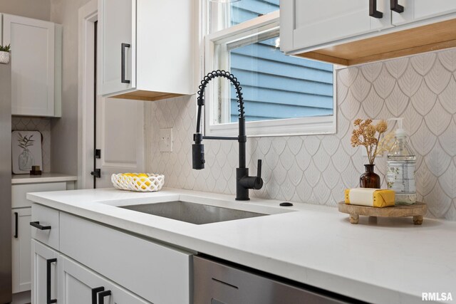 3348 W Lisa Ln, Peoria, IL 61615 - kitchen featuring a sink, backsplash, light countertops, and white cabinetry