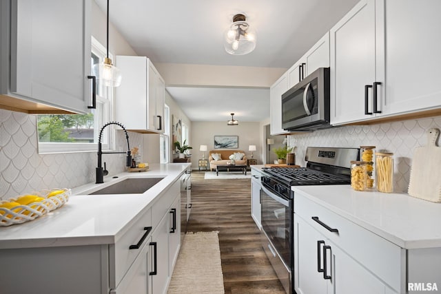 3348 W Lisa Ln, Peoria, IL 61615 - kitchen with stainless steel appliances, a sink, dark wood-style floors, light countertops, and decorative backsplash