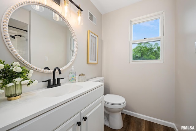 3348 W Lisa Ln, Peoria, IL 61615 - bathroom featuring wood finished floors, toilet, baseboards, vanity, and a shower