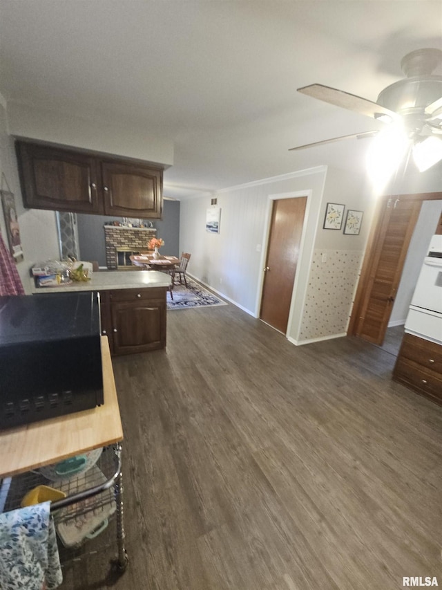 3303 W Chartwell Rd, Peoria, IL 61614 - kitchen with dark wood finished floors, a ceiling fan, a peninsula, ornamental molding, and dark brown cabinetry