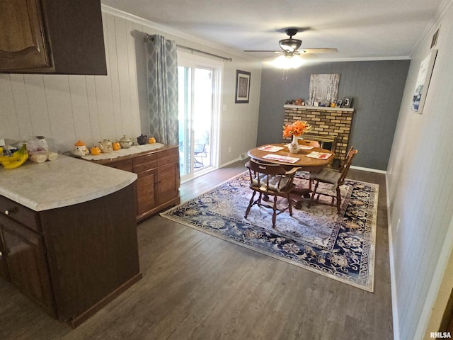 3303 W Chartwell Rd, Peoria, IL 61614 - dining room featuring ornamental molding, wood finished floors, a ceiling fan, a brick fireplace, and baseboards