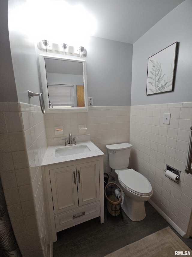 3303 W Chartwell Rd, Peoria, IL 61614 - bathroom with tile walls, toilet, vanity, wood finished floors, and wainscoting