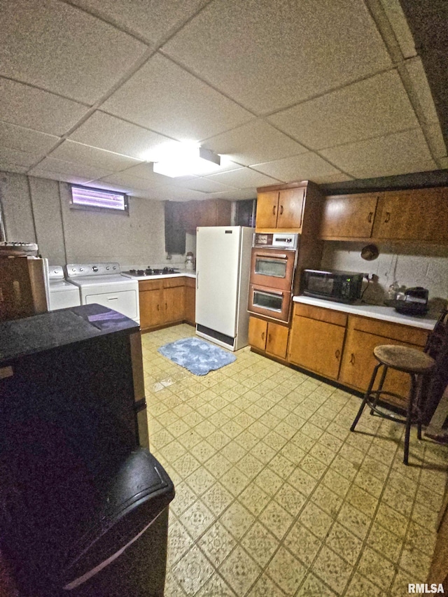 3303 W Chartwell Rd, Peoria, IL 61614 - kitchen featuring freestanding refrigerator, washing machine and clothes dryer, light floors, light countertops, and a paneled ceiling