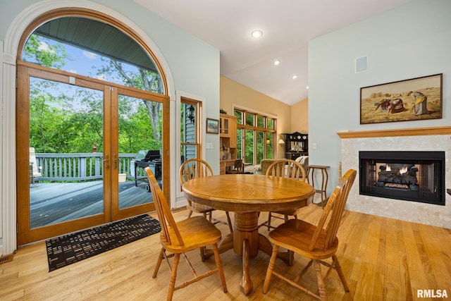131 Lakeside Pl, Dahinda, IL 61428 - dining room featuring french doors, wood-type flooring, healthy amount of natural light, a multi sided fireplace, and high vaulted ceiling