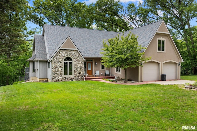 131 Lakeside Pl, Dahinda, IL 61428 - view of front facade featuring a shingled roof, a front lawn, a porch, stone siding, and stucco siding