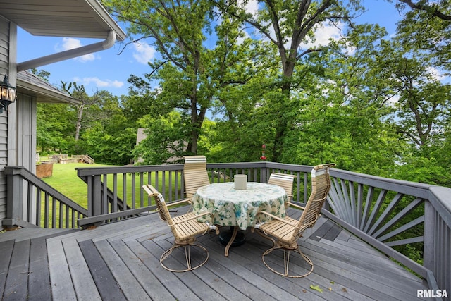131 Lakeside Pl, Dahinda, IL 61428 - wooden terrace featuring outdoor dining area, view of scattered trees, and a yard