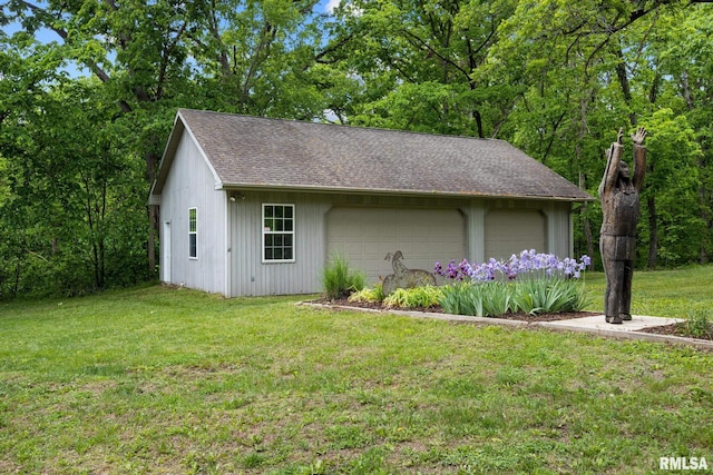 131 Lakeside Pl, Dahinda, IL 61428 - view of side of home featuring an outdoor structure, a detached garage, a yard, and roof with shingles