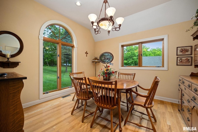 131 Lakeside Pl, Dahinda, IL 61428 - dining area with lofted ceiling, light wood finished floors, a chandelier, and baseboards
