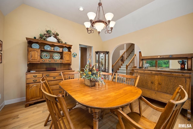 131 Lakeside Pl, Dahinda, IL 61428 - dining room with lofted ceiling, a chandelier, light wood-style flooring, arched walkways, and baseboards