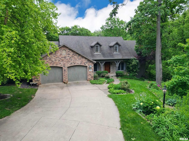 100 W Windflower Way, Dunlap, IL 61525 - cape cod-style house with brick siding, an attached garage, concrete driveway, a front lawn, and roof with shingles