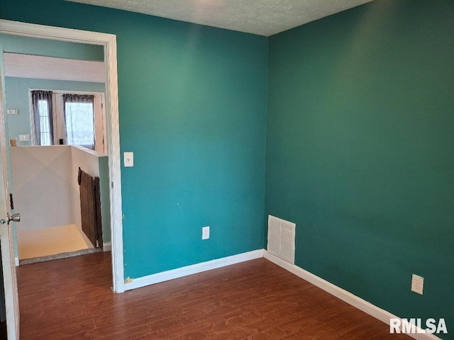 1907 Chicory Rd, Pekin, IL 61554 - unfurnished room with wood finished floors, baseboards, a textured ceiling, and radiator