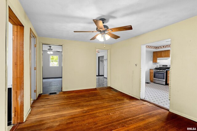 507 E Main St, Bryant, IL 61519 - spare room with hardwood / wood-style floors, a ceiling fan, and baseboards