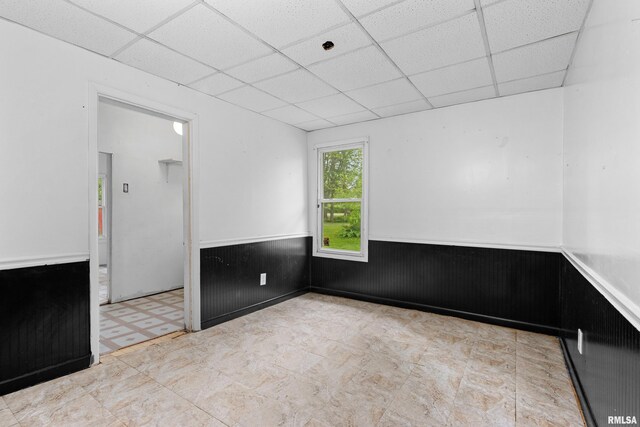 507 E Main St, Bryant, IL 61519 - unfurnished room with a paneled ceiling, tile patterned floors, and wainscoting