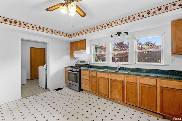 507 E Main St, Bryant, IL 61519 - kitchen with stainless steel gas range oven, a sink, under cabinet range hood, a ceiling fan, and light floors