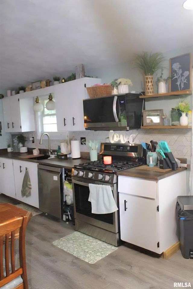 16338 E Red Maple Ln, Lewistown, IL 61542 - kitchen featuring appliances with stainless steel finishes, decorative backsplash, light wood-style floors, dark countertops, and a sink
