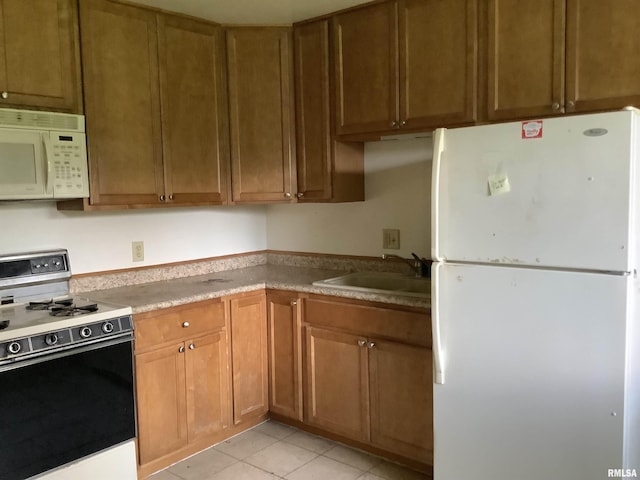 1908 N Idaho St, Peoria, IL 61604 - kitchen with white appliances, a sink, light tile patterned floors, and brown cabinets