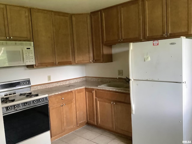 1908 N Idaho St, Peoria, IL 61604 - kitchen featuring white appliances, a sink, light tile patterned flooring, and brown cabinets