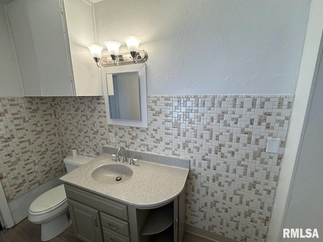 410 E Thrush Ave, Peoria, IL 61603 - half bath with toilet, vanity, and decorative backsplash