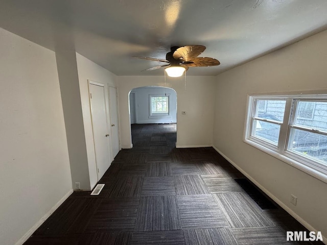 410 E Thrush Ave, Peoria, IL 61603 - unfurnished room featuring arched walkways, ceiling fan, and baseboards