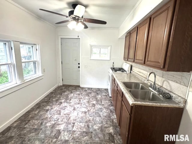 410 E Thrush Ave, Peoria, IL 61603 - kitchen with white range with gas cooktop, a sink, ornamental molding, a ceiling fan, and light countertops